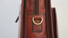porte ordinateur en cuir marron, finition dorée - vue de détail accroche bandoulière en laiton 